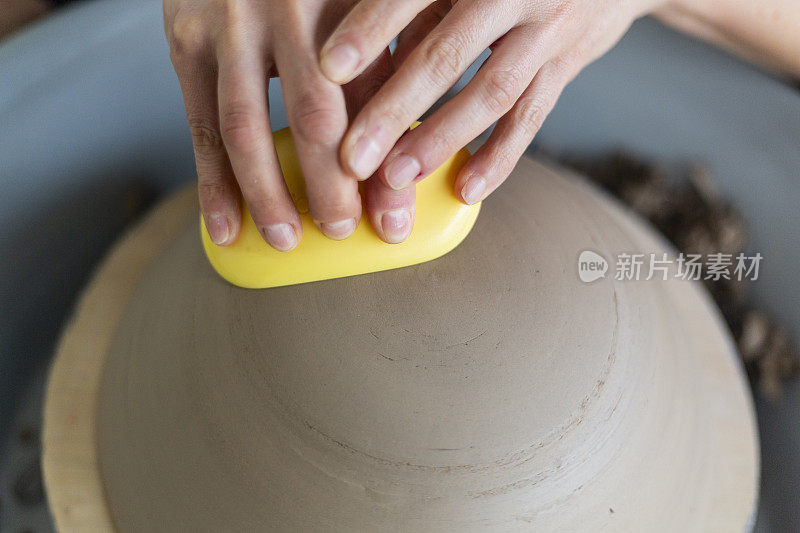 Caucasian woman molding ceramics with her hands